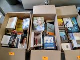 de nombreux livres dans une boîte posée par terre