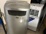 a small air conditioner sitting on the floor next to other appliances