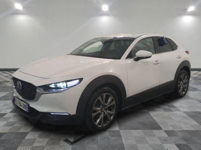 La Mazda CX-HR blanche est garée sur un sol à damier