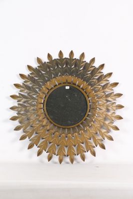 un motif « sunburst » doré et noir sur un mur blanc