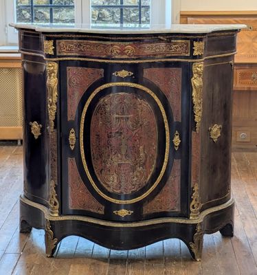 un meuble noir et doré dans une pièce dotée d'une grande fenêtre
