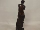 a bronze statue of a woman in a draped dress