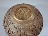 a brown vase with intricate designs on it on a white surface