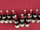 plusieurs bouteilles de vin sont alignées sur une table rouge