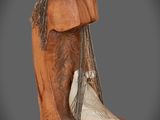 sculpture représentant une botte de cheval d'où pend une corde sur le côté