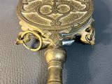 a small brass object with a handle on a table