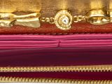 a gold and red purse with a gold design on it