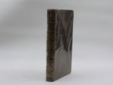 an old book sitting on top of a white surface