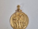 un gros plan d'une médaille d'or sur laquelle figure un ange