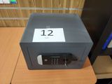 un petit coffre-fort posé sur un bureau, sur lequel figure le chiffre 12