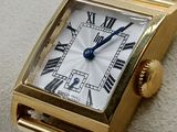 an image of a gold wrist watch with roman numerals on it