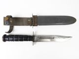 un vieux couteau au manche noir posé à côté d'un couteau plus petit
