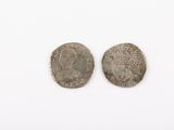 two silver coins, one of which is a woman and one of which is a man