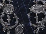 a close up of a blue velvet jacket with a skull on it