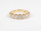 a yellow gold ring with five round diamonds on a white background
