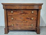 une commode en bois ornée de boutons en laiton