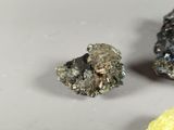 two pieces of metal are sitting on a table next to a piece of yellow substance