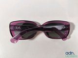 purple sunglasses on a white table with a white background