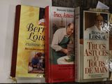 Plusieurs livres de cuisine sont alignés sur une étagère dans une cuisine