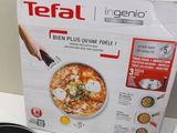 a box of pizza sitting on a table next to a frying pan