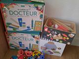 a box of wooden toys on the floor next to a box of wooden toys