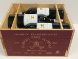 bottles of red wine in a wooden box on a table