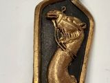 une image représentant une médaille dorée et noire sur laquelle figure un chien