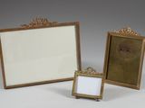 two gold picture frames are sitting next to each other on a white surface