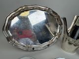 a silver tea pot and a silver tea pot on a table