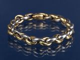 un gros plan d'un bracelet en or et en argent sur un fond bleu