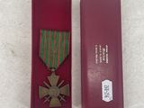 medal in a red case sitting on a white surface next to a red box