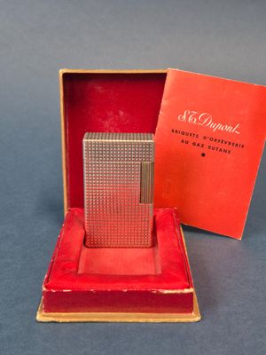 une boîte rouge contenant un briquet argenté