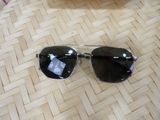 a pair of sunglasses sitting on the floor next to a cell phone
