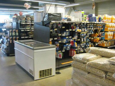 un réfrigérateur au milieu d'un magasin, rempli de sacs de provisions