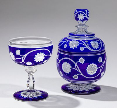 un vase bleu et un verre à vin posés l'un à côté de l'autre