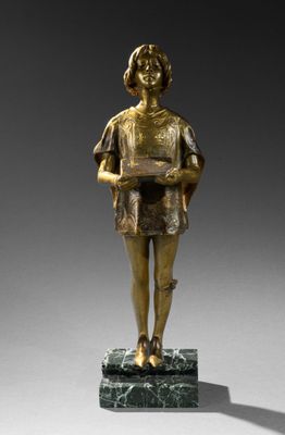 une statue en bronze représentant un garçon tenant un livre