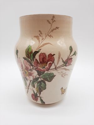 un vase sur lequel sont peintes des fleurs, sur un fond blanc