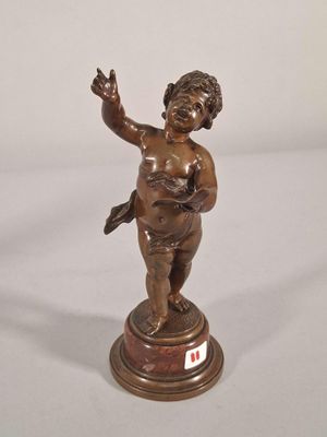 bronze figurine of a boy holding a bird on a pedestal