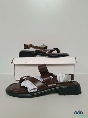 the brown sandals are sitting on top of a white box