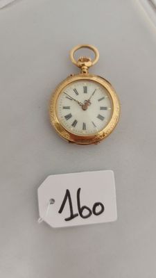 une petite montre de poche en or exposée, accompagnée d'une étiquette de prix