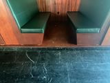 une cabine verte avec deux sièges verts et une horloge accrochée au mur