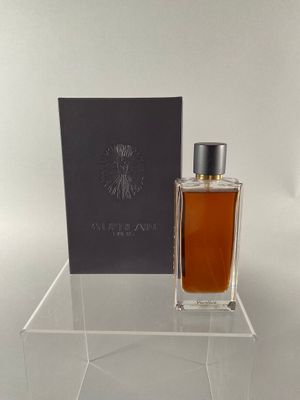 a bottle of perfume sitting on top of a clear table