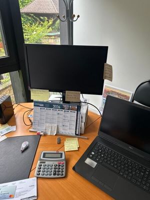 a desk with a laptop and a calculator on it