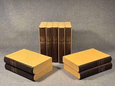 three books are stacked on top of each other on a gray surface