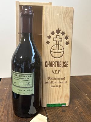 une caisse en bois contenant une bouteille de vin à côté d'un morceau de fromage