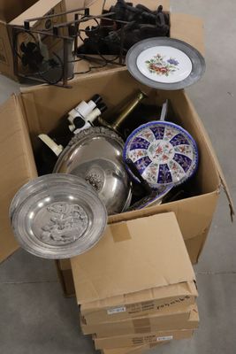 une boîte en carton remplie d'objets hétéroclites sur le sol