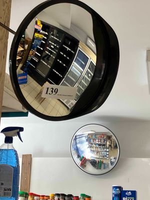 a mirror hanging on the wall above a shelf of cleaning products
