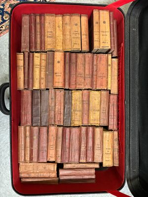a suitcase full of old books sitting on the floor