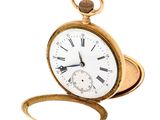 a gold pocket watch with roman numerals on it