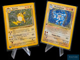 two pokemon cards on display on a black background